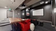 Located in Goodyear, AZ, this dedicated screening room delivers an immersive cinematic experience within a thoughtfully designed space. The room is anchored by a large wall-mounted projection screen paired with a ceiling-mounted projector, creating a true theater-like atmosphere. Dark charcoal walls and a coffered ceiling with recessed and accent lighting set a dramatic, moody tone throughout.

Seating is a standout feature, combining a row of sculptural black-and-red lounge chairs with bold red upholstered sofas, offering flexible viewing arrangements for groups. The patterned carpet in deep gray tones complements the overall color palette, reinforcing the sleek, contemporary aesthetic.

A wet bar area at the rear of the room adds a social and functional element, complete with a live-edge wood countertop bar, dark cabinetry, a sink, and a striking herringbone tile backsplash illuminated by a row of pendant lights — creating an inviting space to gather before or after a screening.

Wall sconces and curated black-and-white artwork with red accents punctuate the walls, adding personality and visual interest. The overall design balances high-end entertainment functionality with modern interior style, making this a versatile and sophisticated space ideal for film screenings, private events, or communal gatherings.