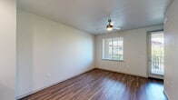 Located on Roseville Pkwy in Roseville, CA, this multi-story home spans three floors and offers 2 bedrooms and 4 bathrooms. The ground floor provides an attached garage with a paneled roll-up door featuring windows for natural light, fluorescent overhead lighting, and direct interior access. The main living level is anchored by an open-concept kitchen and living area finished with rich wood-look flooring throughout. The kitchen is well-appointed with dark espresso cabinetry, white quartz countertops, a subway tile backsplash, stainless steel appliances including a refrigerator, range, and microwave, plus a central island with additional storage and a dedicated sink along the perimeter. A ceiling fan with integrated lighting serves the living area, which benefits from natural light through surrounding windows. The upper floor houses two bedrooms, including a spacious primary suite with plush carpeting, a ceiling fan, and a window with outdoor views. The primary bathroom features a double-sink vanity with dark cabinetry, white countertops, tile flooring, and a glass-enclosed walk-in shower. The remaining bathrooms offer clean, modern fixtures including a round mirror and wood-look flooring. The home's neutral palette and consistent use of quality finishes create a cohesive, modern aesthetic throughout.