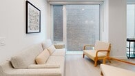 Located at 200 Elgin St in the heart of Ottawa's vibrant downtown core, this thoughtfully designed one-bedroom, one-bathroom unit offers a compact yet highly functional single-floor layout with modern finishes throughout. Light oak hardwood flooring flows seamlessly across the entire unit, creating a warm and cohesive aesthetic against the clean white walls and recessed lighting.

The open-concept kitchen is a standout feature, equipped with full-height white cabinetry, a classic subway tile backsplash, stainless steel appliances including a gas range and refrigerator, and a central island with bar seating—ideal for both cooking and casual dining. A glass pendant light adds a refined touch overhead.

The living room is bright and inviting, benefiting from large floor-to-ceiling windows that fill the space with natural light and provide urban views of the surrounding cityscape. The bedroom is a serene retreat, featuring the same large windows, a full-wall sliding wardrobe with minimalist white panel doors, and matte black hardware accents that echo throughout the unit.

The bathroom is finished to a high standard, showcasing large-format marble-look wall tiles, a frameless glass shower enclosure with matte black trim, and clean, contemporary fixtures. Every detail of this unit reflects a commitment to modern, minimalist design in one of Ottawa's most walkable neighbourhoods.