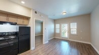 Located at 400 Hillview Ridge Lane in Oroville, CA, this one-bedroom, one-bathroom unit offers a thoughtfully designed single-floor layout. Warm-toned, wood-style flooring runs throughout the entire space, creating a cohesive and inviting atmosphere.

The combined kitchen and living area serves as the heart of the unit. The kitchen is well-equipped with light wood cabinetry offering ample storage, light-toned countertops, a sink, and a full suite of black appliances including a range, refrigerator, and dishwasher. Recessed lighting overhead keeps the space bright and functional.

The living area flows naturally from the kitchen and features large windows fitted with horizontal blinds, allowing for generous natural light and views of the surrounding greenery. The neutral beige walls complement the flooring and lend a calm, versatile backdrop throughout.

The bedroom is a comfortable, quiet retreat with its own window overlooking outdoor foliage, continuing the natural light theme. A set of sliding double-door closets provides practical storage, while the neutral palette keeps the room feeling open and airy.

The bathroom includes a single-sink vanity with light wood cabinetry and a stone-toned countertop, a large mirror, a shower/tub combination, and wood-style flooring that ties back to the rest of the unit. Towel bars and grab rails add functional detail to the well-appointed space.