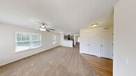 Located at 2560 Bluffs View Dr in Raleigh, NC, this single-story residence offers a thoughtfully designed layout that maximizes comfort and functionality. The combined kitchen and living area forms the heart of the home, with the kitchen showcasing dark espresso cabinetry, granite-style countertops, a double stainless steel sink, and black appliances including a range and refrigerator. Wood-style flooring and a natural light-filled window complete the kitchen's practical, clean aesthetic. The spacious living room features plush carpeting, a ceiling fan, and multiple windows that invite abundant natural light and outdoor views of the surrounding neighborhood. A private door provides direct access to an outdoor balcony or patio area. The generously sized bedroom is carpeted and equipped with its own ceiling fan, double closet doors, and a window for natural light. It connects conveniently to the full bathroom, which features wood-style flooring, a granite-topped vanity with dark cabinetry, and a shower-tub combination. A dedicated walk-in closet with built-in shelving and hanging rods offers excellent storage capacity. Throughout the residence, neutral tones and consistent finishes create a cohesive, comfortable living environment.