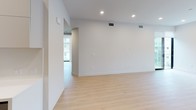 Located at 3833 Dunn Dr in the heart of Los Angeles, this contemporary single-floor unit offers a thoughtfully designed open layout with a clean, modern aesthetic throughout. Light hardwood flooring flows seamlessly across the main living areas, complementing the crisp white walls and recessed lighting that create a bright, inviting atmosphere.

The living area is generously proportioned, offering an open sightline toward the kitchen and providing ample space for a variety of furniture arrangements. A standout feature is the corner wall of floor-to-ceiling sliding glass doors, which floods the space with natural light and frames panoramic views of the surrounding Los Angeles cityscape — an ideal setting for enjoying the vibrant urban environment.

The kitchen is outfitted with sleek, flat-front cabinetry in a two-tone dark and light gray palette, a white countertop with an undermount sink and matte black faucet, and stainless steel appliances including a refrigerator and range, delivering a polished and functional cooking space.

The bathrooms reflect the same modern sensibility, featuring floating vanities with light wood cabinetry, large-format tile, frameless mirrors, and matte black hardware accents. One bathroom includes a tub-shower combination enclosed by a black-framed glass panel and a rainfall showerhead, adding a spa-like quality to the space.