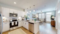 Located in Glendale, Arizona, this thoughtfully designed 3-bedroom, 2-bathroom residence offers a well-appointed single-level layout that maximizes functionality and style. The open-concept kitchen and living area serves as the heart of the home, featuring crisp white cabinetry, a classic subway tile backsplash, granite countertops, and a full suite of stainless steel appliances. A central island with pendant lighting and bar seating provides additional prep space and casual dining options. Light wood-style flooring flows throughout the main living areas, complementing the bright, airy color palette. The living room is generously sized with natural light streaming in through large windows and a glass door that opens to a balcony, complete with a ceiling fan overhead. The bedrooms are carpeted for comfort, each featuring ceiling fans and windows with ample natural light. The primary bedroom is well-proportioned, offering dedicated closet space. The primary bathroom includes a double-sink vanity with granite countertops and a large mirror with bright overhead lighting. The secondary bathroom features a tiled tub-shower combination. Two closets provide practical storage throughout the residence.