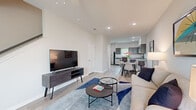 This two-story, two-bedroom, three-bathroom home is thoughtfully designed to maximize both function and comfort across two equally sized floors. The main level features an open-concept layout where the living room, dining area, and kitchen flow seamlessly together. The living room boasts soaring vaulted ceilings, light hardwood-style flooring, a ceiling fan, and recessed lighting. A kitchen anchors the rear of the main floor, equipped with gray shaker-style cabinetry, granite-look countertops, stainless steel appliances, and a breakfast bar that connects to the dining area. A half or full bathroom is also conveniently located on this floor. Upstairs, the primary bedroom is a well-proportioned retreat featuring dual windows that invite abundant natural light, a ceiling fan, and hardwood-style flooring. The second bedroom is equally bright, with large windows and warm wood-toned furnishings. The bathrooms are finished with gray vanity cabinetry, granite-topped counters, and framed mirrors. Neutral tones, clean lines, and consistent flooring throughout the home create a cohesive, modern aesthetic that is both functional and welcoming.