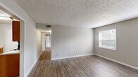 This 2-bedroom, 1-bathroom single-story home in Marietta, Georgia offers a practical and comfortable layout with consistent neutral tones throughout. The living room is a generous, open space finished with warm hardwood-style flooring, a textured ceiling, and a window that lets in natural light — a welcoming area for everyday living. A hallway connects the main living areas to the bedrooms, maintaining a clear and functional flow throughout the home.

The galley-style kitchen is well-equipped, featuring warm honey-toned wood cabinetry, white countertops, a black gas range, dishwasher, and a single-basin sink — providing ample storage and workspace for cooking. The adjacent dining area shares the same hardwood-style flooring, creating a seamless transition.

The primary bedroom is a spacious retreat with dual windows that fill the room with natural light and hardwood-style flooring. It connects to a dedicated walk-in closet with dual shelving rods on both sides, offering substantial storage. The second bedroom is carpeted and features its own closet and window. The shared full bathroom includes a tiled tub-shower combo and classic white fixtures. Throughout, neutral gray walls and white trim provide a clean, move-in-ready aesthetic.