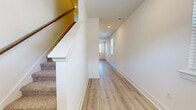 Located at 820 Broadleaf Ln in Smyrna, Tennessee, this two-story home offers a thoughtfully designed layout across two floors. The main level features an open-concept kitchen and living area finished with light hardwood-style flooring throughout. The kitchen is well-equipped with white shaker cabinetry, granite countertops, a subway tile backsplash, stainless steel appliances including a range, microwave, and dishwasher, and a deep undermount sink. A convenient half bathroom with a pedestal sink and oval mirror is also found on this floor. The attached garage provides secure parking with an automatic opener and durable concrete flooring.

Upstairs, the home includes three bedrooms, each carpeted for comfort. The generously sized primary bedroom features a ceiling fan and ample natural light from windows with outdoor views. A spacious walk-in closet with wire shelving serves the primary suite. The secondary bedrooms each include standard closets with built-in wire racking. The upper level is served by two full bathrooms, both featuring granite-topped white vanities, tile flooring, and tub-shower combinations with dark oil-rubbed bronze fixtures. A bright hallway with hardwood-style flooring and recessed lighting connects all upper-level rooms, completing this clean and functional home.