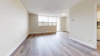 Located at 160 Erskine Ave in Toronto's desirable Midtown neighbourhood, this well-appointed one-bedroom, one-bathroom unit offers a thoughtfully designed layout across a single floor. Hardwood flooring runs throughout, lending warmth and continuity to the space.

The open-concept living and dining area is generously proportioned, bathed in natural light through large floor-to-ceiling windows that frame views of the surrounding cityscape. A sliding door leads directly to a private balcony, extending the living space outdoors. Neutral warm-beige walls complement the light wood tones underfoot, creating a calm and inviting atmosphere.

The kitchen is efficiently laid out with white shaker-style cabinetry, a classic subway tile backsplash, dark countertops, and a full suite of stainless steel appliances including a refrigerator, electric range, and built-in microwave.

The bedroom is a comfortable retreat, featuring its own window with outdoor views, a built-in sliding-door closet, and the same hardwood flooring found throughout the unit. The bathroom is clean and functional, complete with a soaking tub and tiled surround. A hallway connects the rooms, providing a practical and well-organized flow through the entire unit.