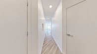 This well-appointed 2-bedroom, 3-bathroom residence in Denver, Colorado offers a clean, modern aesthetic throughout. The open-concept kitchen and living area serves as the heart of the home, featuring light wood-style luxury vinyl plank flooring, recessed lighting, and large windows that invite abundant natural light. The kitchen is outfitted with two-tone cabinetry—dark lower cabinets paired with crisp white uppers—white quartz countertops, a gray tile backsplash, stainless steel Samsung appliances, and a central island ideal for dining or food prep. A sliding glass door leads to a private balcony. The primary bedroom is generously sized with multiple windows and its own en-suite bathroom, which boasts a dual-sink vanity with dark cabinetry, quartz countertops, and a large mirror. The second bedroom features plush carpet, ample natural light, and access to a closet with louvered doors. A dedicated laundry room houses a full-size Samsung washer and dryer. Four closets provide excellent storage throughout. The consistently bright, white-walled interiors paired with light flooring create a fresh, airy ambiance across the entire residence.