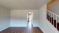Located at 2336 Fairfield Ave in Fairfield, California, this two-story residence offers a clean, modern aesthetic throughout. Rich, dark hardwood-style flooring runs consistently across both floors, providing a cohesive and polished look that contrasts cleanly with the bright white walls and trim found in every room.

The main level features a welcoming living area with a large window that invites natural light and exterior views, alongside a staircase with a white railing leading to the upper floor. The galley-style kitchen is well-equipped with stainless steel appliances — including a refrigerator, gas range, and over-the-range microwave — complemented by white cabinetry, light quartz countertops, and an in-unit washer. A half bathroom on this level features a white vanity with an undermount sink and a backlit mirror.

Upstairs, multiple bedrooms offer comfortable, light-filled spaces, with textured ceilings and ample room for furnishings. One bedroom includes a mirrored sliding-door closet, providing convenient storage. The full bathroom on the upper level is finished with a white vanity, quartz countertop, and a tub-shower combination with clean tile surround. Throughout the home, textured ceilings, neutral tones, and consistent flooring create a cohesive and move-in-ready environment.