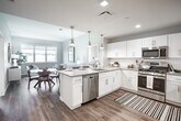 Located at 2930 Rockaway Ave in Oceanside, NY, this thoughtfully designed 2-bedroom, 2-bathroom residence offers a well-appointed single-floor layout with modern finishes throughout. The open-concept kitchen and dining area serves as the heart of the home, featuring crisp white shaker cabinetry, classic subway tile backsplash, quartz countertops, stainless steel appliances, and a central island with pendant lighting — all set atop warm hardwood-style flooring. The living room is bright and airy, bathed in natural light from large windows that frame views of the surrounding neighborhood, complemented by soft, neutral wall tones that create a calm and welcoming ambiance. Both bedrooms are generously sized with ample closet space and large windows that invite natural light. The primary bathroom offers a dual-sink vanity with white cabinetry, a large mirror, and a tiled walk-in shower, while the second bathroom features a single-sink vanity with matching white cabinetry and a tiled shower-tub combination. Clean lines, neutral palettes, and consistent use of quality materials tie the entire residence together, resulting in a cohesive and contemporary living space well-suited for comfortable everyday living.
