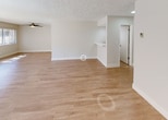 Located at 6060 Buckingham Pkwy in Culver City, California, this single-floor unit offers a clean, updated interior with a neutral color palette throughout. The living area is generously sized, featuring light hardwood-style flooring that extends across the open layout. Large sliding glass doors flood the space with natural light and provide access to a balcony with greenery views, while a ceiling fan adds comfort overhead. The textured ceiling is consistent throughout the main living spaces, lending a classic residential character.

The kitchen has been thoughtfully updated with white shaker-style cabinetry, brushed nickel hardware, white quartz countertops, a deep single-basin sink, and a classic subway tile backsplash. Stainless steel appliances, including a refrigerator and dishwasher, complete the functional and attractive kitchen space.

The bedrooms are carpeted in a light, neutral tone and are well-lit by windows fitted with vertical blinds. Each bedroom offers a calm, comfortable atmosphere with ample wall space. The bathroom is finished with a white dual-sink vanity topped with quartz, a large mirror, a full soaking tub with shower, and light tile flooring, presenting a bright and clean aesthetic. This well-maintained unit combines practical updates with a comfortable, move-in ready layout in a desirable Culver City location.
