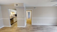 Located at 6300 Crest Green Road in Birmingham, Alabama, this single-floor residence presents a clean, functional layout with neutral tones throughout. The open living area is finished with wood-look luxury vinyl flooring and features a ceiling fan with light fixture, along with a decorative chair rail that runs along the walls, adding subtle architectural detail. A textured ceiling is consistent throughout the main living spaces.

The galley-style kitchen is well-appointed with white cabinetry, granite countertops, a stainless steel sink with pull-down faucet, and stainless steel appliances including a refrigerator, electric range, and over-the-range microwave. The adjacent dining area features matching wood-look flooring and a pendant light fixture overhead.

A hallway connects the living spaces to the private quarters, where multiple bedrooms feature plush carpeting, natural light from windows with blinds, and ceiling fans. At least one bedroom includes a double-door closet for ample storage.

The bathroom includes a full tub and shower combination with tiled surround, alongside a vanity with granite countertops, a framed mirror, and wood-look tile flooring, maintaining a cohesive aesthetic throughout the unit.