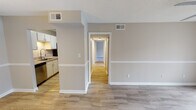 Located at 6300 Crest Green Road in Birmingham, Alabama, this single-floor residence presents a clean, functional layout with neutral tones throughout. The open living area is finished with wood-look luxury vinyl flooring and features a ceiling fan with light fixture, along with a decorative chair rail that runs along the walls, adding subtle architectural detail. A textured ceiling is consistent throughout the main living spaces.

The galley-style kitchen is well-appointed with white cabinetry, granite countertops, a stainless steel sink with pull-down faucet, and stainless steel appliances including a refrigerator, electric range, and over-the-range microwave. The adjacent dining area features matching wood-look flooring and a pendant light fixture overhead.

A hallway connects the living spaces to the private quarters, where multiple bedrooms feature plush carpeting, natural light from windows with blinds, and ceiling fans. At least one bedroom includes a double-door closet for ample storage.

The bathroom includes a full tub and shower combination with tiled surround, alongside a vanity with granite countertops, a framed mirror, and wood-look tile flooring, maintaining a cohesive aesthetic throughout the unit.