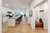 Located at 301 High Tower Blvd in Pittsburgh, PA, this well-appointed 1-bedroom, 1-bathroom residence offers a thoughtfully designed single-floor layout. The open-concept kitchen is a standout feature, showcasing white shaker cabinetry, quartz countertops, stainless steel appliances, and a generously sized center island with bar seating and pendant lighting overhead — ideal for both cooking and casual dining. Light wood-style flooring flows throughout the main living areas, creating a cohesive and contemporary feel. The living room is bright and welcoming, featuring large windows and a glass door that opens to an outdoor area, allowing abundant natural light to fill the space. A built-in entryway nook with bench seating and wall hooks adds a practical yet stylish touch near the entrance. The primary bedroom is a comfortable retreat, complete with a ceiling fan, large windows, and plush carpeting. The full bathroom features a dual-sink vanity with quartz countertops, wood-style flooring, and a tub-shower combination. Additional conveniences include an in-unit laundry area and a dedicated closet. The overall design emphasizes clean lines, neutral tones, and functional living throughout.
