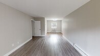Located at 322 Matawan Ave in Cliffwood, NJ, this thoughtfully updated single-floor unit offers a clean, modern aesthetic throughout. The open living and dining area is spacious and bright, featuring durable wood-style plank flooring, neutral gray-toned walls, and generous natural light streaming through large windows and a sliding glass door that opens to an outdoor balcony with views of the surrounding neighborhood. Baseboard heating is present throughout, ensuring year-round comfort.

The bedroom is well-proportioned, offering a built-in closet with rod and shelf storage, a bright window with blinds, and the same warm wood-style flooring that carries through the rest of the unit. An additional room with a window-mounted AC unit provides flexible space for a home office or secondary bedroom.

The kitchen has been fully renovated with rich gray shaker-style cabinetry, crisp white countertops, a stainless steel sink, and a sleek blue-gray subway tile backsplash — creating a sophisticated, contemporary cooking space. The bathroom is equally refined, showcasing floor-to-ceiling marble-look tile in the tub and shower surround, a modern vanity, and a frosted privacy window, delivering a clean and elegant finish throughout.