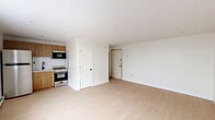 Located at 921 Tyson Ave in Philadelphia's 19111 neighborhood, this efficiently designed unit offers a thoughtful layout across a single floor. The open living area is finished with light-toned laminate flooring and neutral white walls, creating a clean and airy atmosphere throughout. Natural light enters through a double-pane window, complemented by a wall-mounted air conditioning unit and baseboard heating, ensuring year-round comfort. The kitchen is situated along one wall of the main living space and features warm wood cabinetry, a stainless steel gas range, a built-in microwave, and a white subway tile backsplash — a functional and well-organized cooking area. Two closets provide generous storage solutions within the compact footprint. The bathroom is neatly finished with large-format gray tile on both the floor and shower surround, a soaking tub with an overhead shower fixture featuring matte black hardware, a wood-toned vanity, and a toilet — offering a polished, contemporary feel. The overall ambiance of the unit is bright, clean, and practical, making efficient use of every square foot available.