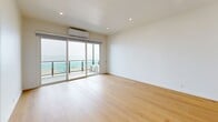 Located along the coveted Coastline Drive in Malibu, California, this 2-bedroom, 3-bathroom residence offers a clean, modern aesthetic complemented by stunning Pacific Ocean views. Light-toned hardwood flooring runs seamlessly throughout the single-floor layout, lending warmth and continuity to every room.

The kitchen is thoughtfully designed with white shaker cabinetry, quartz countertops, a subway tile backsplash, and a full suite of stainless steel appliances including a range, over-the-range microwave, and French door refrigerator. A peninsula provides additional counter space and opens toward the living area. The combined kitchen and living room creates an open, functional layout ideal for everyday living.

The primary bedroom is generously sized, featuring floor-to-ceiling sliding glass doors that open directly onto a private balcony with glass railings and sweeping ocean views. Mirrored sliding closet doors add depth to the secondary bedroom, which also benefits from the warm natural light characteristic of the home.

The bathrooms are finished with clean white cabinetry and quartz surfaces. A standout feature is the walk-in shower adorned with white subway tile, aqua glass mosaic accent tiles, a built-in niche, and a pebble mosaic floor. Recessed lighting throughout ensures a bright, well-lit environment in every room.