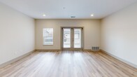 Located at 267 Seminole Rd in Norton Shores, Michigan, this single-story, one-bedroom, one-bathroom unit offers a thoughtfully designed layout that maximizes its compact footprint. The open-concept kitchen and living area serves as the heart of the unit, where light hardwood-style flooring flows throughout, creating a cohesive and bright atmosphere. Recessed lighting illuminates the space, complemented by natural light streaming in through windows and a set of glass French doors in the living room that provide outdoor access and additional brightness.

The kitchen is a standout feature, equipped with medium-toned wood cabinetry, granite countertops, a central island with a built-in sink, stainless steel appliances including a gas range, microwave, and refrigerator, and pendant lighting overhead. A dedicated range hood adds both function and visual interest.

The bedroom offers a comfortable, carpeted retreat with a double-door closet and a window fitted with vertical blinds for light control. The bathroom is finished with warm wood-tone cabinetry topped with granite, light hardwood-style flooring, and a full tub-shower combination with a curved curtain rod and brushed nickel fixtures. Neutral tones throughout the unit create a clean, modern aesthetic.