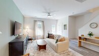 Located at 1491 Bees Ferry Road in Charleston, SC, this two-story home offers three bedrooms and three bathrooms across a well-organized layout. The ground floor welcomes residents through a dedicated entrance that flows into a bright, open living room finished with light wood flooring, neutral walls, and a ceiling fan that enhances airflow and comfort. Large windows invite natural light throughout, creating a warm and airy ambiance. The galley-style kitchen is outfitted with grey shaker cabinetry, white quartz countertops, a subway tile backsplash, and stainless steel appliances, including a range, microwave, dishwasher, and refrigerator. A pantry provides additional storage, and a convenient laundry area is also found on this level. The ground floor includes a half bath and access to both the garage and a private patio with outdoor space. Upstairs, the upper floor houses all three bedrooms, including a generously sized primary suite with its own closet. The additional bedrooms are carpeted and well-lit with natural light from windows. Three full bathrooms are clean and modern, featuring tub-shower combinations and white vanities. Hallways connect each area smoothly, and multiple closets ensure ample storage throughout this efficiently designed Charleston home.