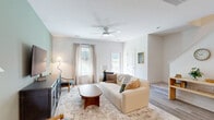 Located at 1491 Bees Ferry Road in Charleston, SC, this two-story home offers three bedrooms and three bathrooms across a well-organized layout. The ground floor welcomes residents through a dedicated entrance that flows into a bright, open living room finished with light wood flooring, neutral walls, and a ceiling fan that enhances airflow and comfort. Large windows invite natural light throughout, creating a warm and airy ambiance. The galley-style kitchen is outfitted with grey shaker cabinetry, white quartz countertops, a subway tile backsplash, and stainless steel appliances, including a range, microwave, dishwasher, and refrigerator. A pantry provides additional storage, and a convenient laundry area is also found on this level. The ground floor includes a half bath and access to both the garage and a private patio with outdoor space. Upstairs, the upper floor houses all three bedrooms, including a generously sized primary suite with its own closet. The additional bedrooms are carpeted and well-lit with natural light from windows. Three full bathrooms are clean and modern, featuring tub-shower combinations and white vanities. Hallways connect each area smoothly, and multiple closets ensure ample storage throughout this efficiently designed Charleston home.