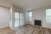This single-story, one-bedroom, one-bathroom residence in Columbia, SC offers a thoughtfully designed layout that maximizes its efficient footprint. The living room serves as the heart of the home, showcasing warm wood-look luxury vinyl flooring, a tile-surround fireplace, and abundant natural light streaming through multiple windows and a full-width sliding glass door that opens to an outdoor patio. The vaulted ceiling in the living area enhances the sense of openness throughout.

The kitchen is a standout feature, equipped with crisp white upper cabinetry, gray lower cabinets with matte black hardware, sparkling quartz countertops, a peninsula with a single-basin sink, stainless steel appliances including a range and refrigerator, and overhead skylight-style lighting that brightens the entire cooking space.

The bedroom is a comfortable retreat finished with plush carpet, a ceiling fan with light fixture, and a natural light window. It offers access to two closets, providing generous storage. The full bathroom features wood-look flooring, a clean white vanity with ample counter space and cabinetry, and matte black hardware accents that lend a modern touch. A dedicated laundry area rounds out the functional layout of this move-in-ready residence.