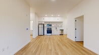 Located at 39 NE Kelly Ave in Gresham, Oregon, this thoughtfully designed 3-bedroom, 1-bathroom unit offers a clean, contemporary aesthetic throughout its single-floor layout. Light wood-tone flooring flows seamlessly across all areas, complementing the crisp white walls and modern black hardware accents that define the space.

The open-concept kitchen and living area serves as the heart of the unit. The kitchen is outfitted with stainless steel appliances, including a refrigerator, electric range, over-the-range microwave, and dishwasher. White shaker-style cabinetry with matte black pulls pairs with a white subway tile backsplash and light countertops to create a bright, functional cooking space.

A dedicated in-unit laundry area features a stacked Whirlpool washer and dryer, offering a practical convenience within the unit. The full bathroom is finished with a white vanity, matching cabinetry, matte black fixtures, and a tub/shower combination.

The primary bedroom provides a comfortable retreat with access to a private balcony and views of the surrounding greenery. The additional bedrooms each include closets — one with a sliding door and one with a reach-in configuration. Natural light enters through well-placed windows, enhancing the overall bright and airy ambiance throughout this well-appointed Gresham residence.