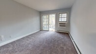 Located on Ken Kora Lane in Woodbury, NY, this single-floor residence offers a thoughtfully updated interior with a clean, neutral aesthetic throughout. The living area is generously sized, finished with plush carpeting and painted in a soft gray-blue palette. Sliding glass doors open directly to an outdoor space, allowing natural light to pour in and providing easy exterior access. A wall-unit air conditioner and baseboard heating ensure year-round comfort.

The kitchen has been renovated to include white shaker-style cabinetry, granite countertops, a classic subway tile backsplash, and a full suite of stainless steel appliances, including a gas range, built-in microwave, and dishwasher. Light wood-look flooring and a bright window contribute to an open, airy feel.

The bedroom is well-proportioned, also carpeted, and features large windows that bring in ample natural light, accompanied by a wall-unit AC and baseboard heating. A dedicated in-unit laundry closet with a stacked washer and dryer adds notable convenience.

The bathroom is elegantly finished with white subway tile surrounding a full soaking tub, a marble-top white vanity, and brushed gold hardware, lending a refined touch to the space.