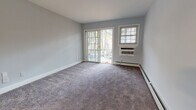 Located on Ken Kora Lane in Woodbury, NY, this single-floor residence offers a thoughtfully updated interior with a clean, neutral aesthetic throughout. The living area is generously sized, finished with plush carpeting and painted in a soft gray-blue palette. Sliding glass doors open directly to an outdoor space, allowing natural light to pour in and providing easy exterior access. A wall-unit air conditioner and baseboard heating ensure year-round comfort.

The kitchen has been renovated to include white shaker-style cabinetry, granite countertops, a classic subway tile backsplash, and a full suite of stainless steel appliances, including a gas range, built-in microwave, and dishwasher. Light wood-look flooring and a bright window contribute to an open, airy feel.

The bedroom is well-proportioned, also carpeted, and features large windows that bring in ample natural light, accompanied by a wall-unit AC and baseboard heating. A dedicated in-unit laundry closet with a stacked washer and dryer adds notable convenience.

The bathroom is elegantly finished with white subway tile surrounding a full soaking tub, a marble-top white vanity, and brushed gold hardware, lending a refined touch to the space.