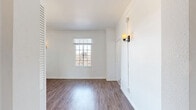 Located at 535 S Gramercy Place in the Koreatown neighborhood of Los Angeles, this compact yet efficiently laid-out unit offers a cohesive, well-appointed living experience across a single floor. The space includes a living room, kitchen, bathroom, hallway, and two closets.

The living room is bright and airy, featuring rich hardwood-style flooring, crisp white walls, elegant crown molding, and a classic cast-iron radiator. Grid-paned windows allow natural light to fill the room, while wall-mounted sconce lighting adds a warm, curated ambiance. A louvered closet door provides convenient built-in storage.

The kitchen stands out with its bold black-and-white encaustic-style patterned floor tiles, which contrast beautifully against white shaker-style cabinetry and dark countertops. Stainless steel appliances—including a gas range and refrigerator—complete the functional and stylish cooking space. A window above the sink brings in additional natural light.

The bathroom continues the patterned tile motif on the floor, maintaining design consistency throughout the unit. White subway tile lines the walls of the tub-shower combination, creating a clean and classic look.

Throughout the space, the consistent use of white tones, natural light, and thoughtful design details create a polished and inviting atmosphere well-suited for urban living in Los Angeles.