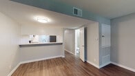Located at 490 E Wilbur Rd in Thousand Oaks, California, this two-story residence offers a clean, modern aesthetic with thoughtfully updated finishes throughout. The layout is spread across two levels, with living areas on the main floor and bedrooms situated upstairs, connected by a staircase visible in the floor plan.

The kitchen is a standout feature, showcasing a two-tone cabinet design with crisp white upper cabinets and slate gray lower cabinets, all complemented by marble-style quartz countertops. Stainless steel appliances, including a refrigerator, dishwasher, microwave, and range, provide a cohesive, contemporary look. A pass-through window connects the kitchen to the adjacent living area, which features warm wood-look plank flooring and neutral gray walls. Large vertical blinds allow natural light to fill the main living space.

The bathrooms mirror the kitchen's refined aesthetic, featuring the same marble-style quartz countertops, undermount sinks, and brushed nickel fixtures. One bathroom includes a full tub-shower combination with updated hardware.

The upper-level bedrooms are finished with plush carpeting and neutral-toned walls, offering a comfortable and quiet retreat. Windows in the bedrooms provide natural light and views of the surrounding greenery, contributing to the overall bright and welcoming atmosphere of this Thousand Oaks residence.