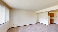 Located at 3403 Jersey Ridge Rd in Davenport, Iowa, this 2-bedroom, 1-bathroom unit offers a practical and well-organized single-floor layout. The living area features neutral-toned walls, wall-to-wall carpeting, and a textured ceiling, creating a clean and understated atmosphere throughout.

The kitchen is efficiently designed with warm wood-toned cabinetry offering ample upper and lower storage, a laminate countertop with an integrated sink, and wood-look flooring. White appliances, including a refrigerator and range, complete the functional space.

Both bedrooms are carpeted and feature large windows that bring in natural light and views of the surrounding neighborhood. Each bedroom is equipped with a built-in closet, providing practical storage. The spacious primary bedroom offers a generous footprint, while the second bedroom is well-proportioned for its purpose.

A central hallway connects the main living areas to the bedrooms and bathroom, creating a logical flow throughout the unit. The bathroom includes a full tub-shower combination with clean white surround panels and chrome fixtures.

Overall, this unit presents a straightforward, functional design with consistent finishes, neutral tones, and adequate natural light, making it a practical residence in Davenport, IA.