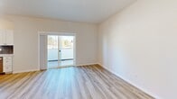 Located at 324 N Arthur St in Kennewick, Washington, this 2-bedroom, 2-bathroom unit offers a well-organized single-floor layout designed for comfortable, everyday living. Light-toned luxury vinyl plank flooring runs throughout, lending a cohesive, clean aesthetic to every room.

The kitchen features white shaker cabinetry, a blue-gray tile backsplash, stainless steel appliances including a refrigerator and microwave, and an electric range—all arranged in a galley-style configuration that maximizes efficiency. It connects directly to the combined living area, which benefits from a sliding glass door that opens to a private balcony, allowing natural light and outdoor views to enhance the space.

The primary bedroom is a comfortable size and includes a walk-in closet outfitted with dual hanging rods and shelving. Its en-suite bathroom features a glass-enclosed shower with dark bronze fixtures. The second bedroom offers two windows with views of mature trees and a bright, neutral interior. The second bathroom provides a full soaking tub with a shower and matching dark bronze hardware.

A dedicated laundry closet houses a stacked Whirlpool washer and dryer, adding convenience. Throughout the unit, white walls, recessed lighting, and clean architectural lines contribute to a fresh, modern ambiance.