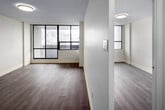 Located on the 16th floor at 33 Wood St in the heart of Toronto, this one-bedroom, one-bathroom unit offers an efficient and well-appointed layout across a single floor. The living room is a bright, open space anchored by large floor-to-ceiling windows with bold black frames, offering sweeping views of the downtown Toronto skyline and flooding the room with natural light. Light-toned laminate flooring flows consistently throughout the unit, contributing to a clean, cohesive aesthetic.

The kitchen is thoughtfully renovated, featuring white shaker-style cabinetry, stone-look countertops, a stainless steel refrigerator, and a tiled backsplash in warm earth tones. The kitchen is separated from the living area by a partial wall, creating a defined yet open feel.

The bedroom is a comfortable, quiet retreat with a mirrored sliding closet and a window providing additional natural light and city views. The bathroom stands out as a refined space, finished with large-format marble-look wall tiles and a sleek glass-enclosed walk-in shower complete with a built-in niche and contemporary chrome fixtures.

An entrance and hallway complete the layout, providing practical transitional space. This well-maintained unit combines modern finishes with an unbeatable downtown Toronto location.