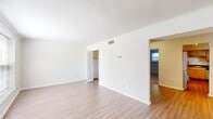Located at 1000 Old Brook Road in Charlottesville, Virginia, this two-bedroom, one-bathroom single-floor residence offers a practical and comfortable layout. Crown molding and light wood-look flooring run throughout the main living areas, lending a clean, cohesive aesthetic. The living room is bright and open, with a large window that allows natural light to fill the space and a front entry door that connects seamlessly to the rest of the unit. An open passage leads toward the kitchen and bedrooms, making for an efficient and easy-to-navigate floor plan. The kitchen is well-appointed with warm natural wood cabinetry, dark countertops, stainless steel appliances including a dishwasher and over-range microwave, and a window above the sink that brings in additional light. Both bedrooms feature plush carpeting and crown molding, with the primary bedroom offering a spacious walk-in closet and a second bedroom providing a bright window with outdoor views. The shared bathroom includes a wood-toned vanity, a mirrored medicine cabinet, and wood-look flooring. A hallway and dedicated closet provide additional storage. This residence combines functional design with comfortable finishes throughout.