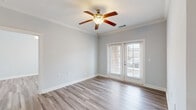 Located at 101 Tomshire Dr in Charleston, SC, this single-floor residence offers a thoughtfully designed open layout with a clean, contemporary aesthetic. The interior is finished with a combination of light marble-style tile and wood-look flooring that flows seamlessly between spaces, complemented by soft neutral wall tones and crisp white trim and crown molding throughout.

The kitchen is a standout feature, equipped with rich dark cabinetry, granite-style countertops, and a full suite of stainless steel appliances including a refrigerator, range, and over-the-range microwave. A decorative column with detailed molding accents the transition between the kitchen and hallway, adding architectural character.

The living area is bright and airy, featuring a ceiling fan with light fixture and French doors that open to a private balcony with brick exterior detailing, offering views of the surrounding greenery. The bedrooms are generously sized with wood-look flooring, large windows with plantation shutters that invite natural light, and neutral walls that create a calm atmosphere.

The bathroom includes dark vanity cabinetry with granite-style countertops and tile flooring, offering a polished and functional design. A dedicated laundry area with tile flooring, overhead wire shelving, and utility hookups rounds out the practical amenities of this well-appointed Charleston residence.