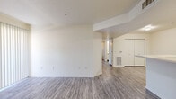 This single-floor, 3-bedroom, 2-bathroom residence offers a practical and efficient layout designed to maximize everyday comfort. The open living area features light gray wood-look flooring and a sliding glass door fitted with vertical blinds, allowing natural light to fill the space while providing outdoor access. A smooth transition leads into the galley-style kitchen, which is outfitted with white cabinetry accented by warm wood trim, white appliances including a range and refrigerator, ample counter space, and a double-basin sink — making it a highly functional workspace.

The three bedrooms are carpeted for comfort, each featuring windows with vertical blinds that invite natural light. The primary bedroom is a generously sized retreat, while the two secondary bedrooms offer closet storage. One closet is a spacious walk-in with wire shelving, while another features a standard sliding-door closet with a built-in rod.

The two bathrooms are clean and functional, each featuring wood-trimmed vanities with light countertops, large mirrors, and wood-look flooring. One bathroom includes a shower/tub combination. The unit is completed by a dedicated laundry area, adding notable convenience. Throughout, the neutral white and beige palette creates a bright, move-in-ready atmosphere.