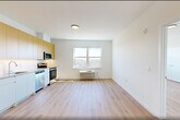 This thoughtfully designed two-bedroom, two-bathroom unit at 431 Doctor Martin Luther King Junior Boulevard in East Orange, NJ offers a clean, contemporary living experience across a single floor. Light-toned hardwood flooring runs throughout, lending warmth and continuity to every room.

The open main living area flows seamlessly into a modern kitchen outfitted with stainless steel appliances — including a refrigerator, electric range, built-in microwave, and dishwasher — complemented by two-tone cabinetry featuring natural wood uppers and crisp white lower cabinets with light countertops.

Both bedrooms are bright and well-proportioned, each benefiting from large windows that invite abundant natural light and offer outdoor views of the surrounding East Orange neighborhood. A wall-mounted PTAC unit in each bedroom provides individual climate control. The spacious primary bedroom includes a generously sized built-in closet system with shelving and hanging rods for organized storage.

The two bathrooms are clean and modern — one features a tiled tub/shower combination, while the other offers a glass-enclosed shower stall, both paired with white vanities and neutral tile finishes. Additional conveniences include three closets, a dedicated laundry area, and an entry corridor that provides a practical transition into the main living spaces.