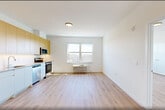 This thoughtfully designed two-bedroom, two-bathroom unit at 431 Doctor Martin Luther King Junior Boulevard in East Orange, NJ offers a clean, contemporary living experience across a single floor. Light-toned hardwood flooring runs throughout, lending warmth and continuity to every room.

The open main living area flows seamlessly into a modern kitchen outfitted with stainless steel appliances — including a refrigerator, electric range, built-in microwave, and dishwasher — complemented by two-tone cabinetry featuring natural wood uppers and crisp white lower cabinets with light countertops.

Both bedrooms are bright and well-proportioned, each benefiting from large windows that invite abundant natural light and offer outdoor views of the surrounding East Orange neighborhood. A wall-mounted PTAC unit in each bedroom provides individual climate control. The spacious primary bedroom includes a generously sized built-in closet system with shelving and hanging rods for organized storage.

The two bathrooms are clean and modern — one features a tiled tub/shower combination, while the other offers a glass-enclosed shower stall, both paired with white vanities and neutral tile finishes. Additional conveniences include three closets, a dedicated laundry area, and an entry corridor that provides a practical transition into the main living spaces.