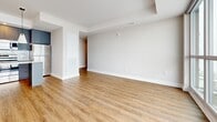 Located at 929 Richmond Rd in Ottawa's vibrant west end, this well-appointed 2-bedroom, 2-bathroom unit offers a thoughtfully designed open-concept layout spread across a single floor. Warm-toned luxury vinyl plank flooring runs throughout, complementing the neutral palette of the crisp white walls and trim.

The combined kitchen and living area forms the heart of the unit. The contemporary kitchen features sleek grey flat-panel cabinetry with gold hardware, a herringbone tile backsplash, stainless steel appliances, and a central island with a light quartz countertop — ideal for both meal prep and casual dining. The adjacent living area opens to a private balcony through expansive floor-to-ceiling sliding glass doors, flooding the space with natural light and offering sweeping views of the Ottawa skyline.

Both bedrooms are comfortably sized with large windows that frame city and neighbourhood views. The primary bedroom benefits from generous proportions and dedicated closet space. A second closet and in-unit laundry add further practicality.

The two bathrooms are finished with clean, modern detailing — one features hexagonal mosaic tile flooring and a dark vanity, while the other includes a soaker tub with classic white subway tile surround. Together, they deliver a polished, functional finish throughout.