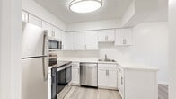 Located at 2801 Park Center Drive in Alexandria, VA, this 2-bedroom, 3-bathroom residence offers a thoughtfully designed single-floor layout with a clean, modern aesthetic. The open living area is bathed in natural light through large sliding glass doors that lead to a private balcony overlooking lush greenery, creating an airy and inviting atmosphere. Light-toned hardwood-style flooring runs throughout the main living spaces, complementing the crisp white walls and textured ceilings.

The kitchen is well-appointed with white shaker-style cabinetry, light stone countertops, a stainless steel sink, and a full suite of stainless steel appliances, including a refrigerator, range, microwave, and dishwasher. It provides ample storage and a practical layout ideal for everyday use.

Both bedrooms are generously sized, featuring plush carpeting, natural light from windows with blinds, and access to closet space. The primary bedroom is notably spacious and includes a walk-in closet with built-in shelving and hanging rods for organized storage. The three bathrooms are clean and bright, each featuring tub-shower combinations with tiled surrounds and updated fixtures. The entrance and hallway offer a welcoming transition into the home's well-organized floor plan.