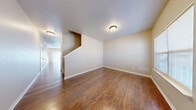 Located on Raven St in Fort Riley, Kansas, this two-story, 4-bedroom, 3-bathroom home offers a functional and comfortable layout evenly divided between two floors. The main level features rich hardwood-style flooring throughout the living room, dining room, and kitchen. The living room is open and airy, with a staircase leading to the upper level. The adjacent dining area is highlighted by a classic chandelier and sliding glass door that invites natural light. The kitchen is well-equipped with warm wood cabinetry, ample counter space, and white appliances including a range, dishwasher, and refrigerator. Upstairs, the second living area provides additional flexible space, also finished with hardwood-style flooring. The four bedrooms are carpeted in neutral tones and feature windows that bring in natural light. The generously sized primary bedroom offers notable space. Three full bathrooms serve the home, each finished with tile flooring, warm wood vanities with dual sinks, and a tub-shower combination. Neutral warm tones throughout the home create a cohesive and welcoming atmosphere, making this a practical and comfortable residence well-suited for Fort Riley families.