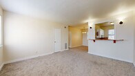 Located at 602 Virginia Ave in Savannah, Georgia, this single-story, two-bedroom, one-bathroom residence offers a practical and well-organized layout. The entry introduces the space with tile flooring that transitions into wall-to-wall carpeting throughout the main living areas. The combined living and dining room is open and simply appointed, with warm neutral walls and a chandelier overhead that anchors the dining portion. A half-wall with a breakfast bar separates this area from the kitchen, which features white cabinetry, brown laminate countertops, a mosaic tile backsplash in earthy tones, a stainless steel sink, and a white range, all illuminated by a window overlooking the exterior.

The primary bedroom offers ample closet storage, with multiple doors providing organized access to closet and utility spaces. The second bedroom includes its own window for natural light and a dedicated closet. Both rooms are carpeted and finished in neutral tones. The hallway connects the bedrooms efficiently to the shared bathroom, which stands out with bold black-and-white checkered wall and floor tile, a pedestal sink, a soaking tub with grab bar, and a bright window — a distinctive design feature within an otherwise understated home.