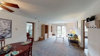 This single-floor residence offers a thoughtfully designed layout that balances comfort and functionality across several distinct living spaces. The open-concept living room is generously proportioned, featuring soft carpeting, neutral walls, and a sliding glass door that invites natural light and provides outdoor views. A built-in shelving unit adds both storage and character to the space, while a separate seating area flows naturally toward the dining room.

The dining room is distinguished by a vibrant teal accent wall and a ceiling fan, creating a lively yet intimate atmosphere for gatherings. The kitchen is equipped with warm oak cabinetry, light countertops, and black appliances including a range, dishwasher, and refrigerator, all set atop easy-care hard flooring.

The primary bedroom is spacious, with dual windows and plush carpet, offering a calm retreat. A second bedroom provides ample space for a bed and desk, also featuring natural light and carpet. The primary bathroom includes a walk-in closet and a separate water closet, while a second full bathroom offers a tub-shower combination with wood-toned cabinetry and hard flooring throughout.