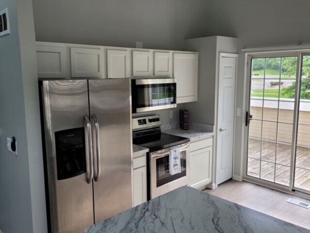 Kitchen with adjacent patio features brand-new stainless steel appliances. - 6616 Bellows Ct