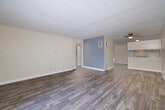 Located at 6595 Montezuma Rd in San Diego, CA, this single-floor, one-bedroom, one-bathroom unit offers a well-organized layout across a comfortable footprint. The open-concept living and dining area is highlighted by wood-style plank flooring, neutral cream-toned walls, a textured ceiling, and a ceiling fan. A large window with vertical blinds allows natural light to fill the space, while a distinctive blue vertical-panel accent wall adds a touch of character near the entryway. The kitchen is efficiently laid out in an L-shape configuration, featuring white cabinetry with ample upper and lower storage, white appliances including a range and refrigerator, a double-basin sink, and light countertops — all set on matching wood-style flooring. The dining area adjoins the kitchen seamlessly, with an additional window providing natural light. The spacious bedroom is carpeted for comfort, with a large window fitted with vertical blinds and access to a generously sized walk-in closet complete with built-in shelving and hanging rods. The full bathroom offers a long vanity with under-cabinet storage, a wall-length mirror, and a shower with a glass enclosure, all finished with light wood-style tile flooring.