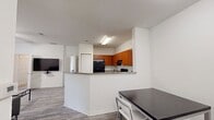 This contemporary 1070 square foot apartment offers a thoughtful layout with 3 bedrooms and 2 bathrooms. The heart of the home is an open-concept kitchen and living area, featuring warm wood cabinetry, granite countertops, and black appliances. The kitchen's U-shape design provides ample workspace and storage.

Throughout the apartment, grey wood-look flooring creates a cohesive and modern aesthetic. The bathrooms showcase a combination of functionality and style with tiled shower/tub units, granite vanity tops, and wood cabinetry matching the kitchen.

Each bedroom is equipped with a ceiling fan for comfort and wire shelving in the closets for organization. The primary bedroom, measuring 190 square feet, offers a spacious retreat. The living room features large windows and a glass door, allowing natural light to flood the space and providing access to an outdoor area.

The apartment's neutral color palette, consisting of white walls and warm wood tones, creates a blank canvas for personal style. Additional amenities include in-unit laundry facilities and multiple closets throughout, ensuring ample storage space. The overall design prioritizes functionality and modern living in a compact yet comfortable setting.
