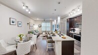 Located in Seabrook, TX, this well-appointed one-bedroom, one-bathroom residence offers a seamless open-concept layout that connects the kitchen, dining, and living areas into one cohesive, light-filled space. Crown molding and wood-style flooring run throughout the main living areas, lending a polished, contemporary feel.

The kitchen is a standout feature, boasting rich dark cabinetry, stainless steel appliances including a side-by-side refrigerator and range, a subway tile backsplash, and an expansive granite-topped island with bar seating — ideal for both everyday meals and entertaining. Pendant and track lighting illuminate the space with a warm, modern glow.

The living room offers generous natural light through large windows dressed with sheer curtains, complemented by a ceiling fan and direct access to the outdoors. The dining area, framed by a glass-top table and upholstered chairs, flows naturally from both the kitchen and living room.

The bedroom features plush carpeting, a ceiling fan, and French doors that open to a private balcony with scenic outdoor views. The spacious walk-in closet provides ample storage. The bathroom is elegantly finished with a dual-sink granite vanity, decorative tile flooring, a soaking tub, and a glass-enclosed shower. In-unit laundry adds everyday convenience.