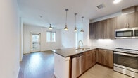 Located at 3765 Canfield St in Boulder, Colorado, this well-appointed 2-bedroom, 2-bathroom single-floor residence offers a thoughtfully designed layout with modern finishes throughout. The open-concept kitchen is a standout feature, showcasing rich wood-toned cabinetry that extends to the ceiling, a striking central island with a dark quartz countertop and gold-accented faucet, subway tile backsplash, and a full suite of stainless steel appliances including a French door refrigerator, range, microwave, and dishwasher. Pendant lighting above the island adds a warm, contemporary touch. The kitchen flows seamlessly into the living area, which features light wood-look flooring and a ceiling fan, with a door providing access to the outdoors. The primary bedroom is a comfortable retreat with plush carpeting, a ceiling fan, and a walk-in closet with dual hanging rods. The bathrooms are finished with warm wood vanities, quartz countertops, and a glass-enclosed tile shower. A dedicated in-unit laundry closet houses a full-size side-by-side washer and dryer. Recessed lighting and clean white walls create a bright, cohesive ambiance throughout, making this Boulder residence both functional and stylish.