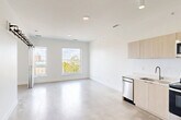 Located in Detroit's vibrant Midtown neighborhood, this 1-bedroom, 1-bathroom unit at 3740 Second Ave offers a thoughtfully designed, modern living space. The open-concept main area seamlessly integrates the living room, dining area, and kitchen, all unified by polished concrete floors that extend throughout the unit. Large windows flood the space with natural light and frame views of the surrounding Detroit skyline and cityscape.

The kitchen features light wood cabinetry, a full suite of stainless steel appliances including a refrigerator, range, microwave, and dishwasher, and a clean white countertop. A striking barn door on a black metal track serves as a stylish partition, adding an industrial-modern accent to the living area.

The bedroom is a cozy, well-defined space with its own closet storage. The bathroom is clean and functional, featuring white subway tile in the walk-in shower, polished concrete floors, and recessed lighting. Additional storage is provided by two closets, and a dedicated laundry area adds everyday convenience. The unit's crisp white walls, recessed lighting, and minimalist aesthetic create a bright, airy atmosphere throughout.