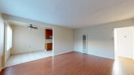 Located at 11700 Glenoaks Blvd in Los Angeles, CA, this one-bedroom, one-bathroom unit offers a functional and comfortable single-floor layout. The living room is a bright, open space featuring warm hardwood-style flooring, neutral-toned walls, a wall-mounted heater unit, and a large picture window with vertical blinds that fills the room with natural light and provides views of the exterior. An entryway with tile flooring connects seamlessly to the main living area.

The combined dining and kitchen area transitions to light tile flooring and is anchored by classic warm-toned wood cabinetry that lines the walls, complemented by a tile backsplash and a ceiling fan that aids in ventilation. The kitchen layout is galley-style, offering efficient use of space with ample upper and lower cabinet storage.

The bedroom is a comfortably sized retreat with the same hardwood-style flooring found throughout. It features built-in floor-to-ceiling cabinetry and closet storage along one wall, along with a sunlit window dressed with vertical blinds. The bathroom is clean and straightforward, featuring a tub/shower combination with a sliding glass enclosure, wood-style flooring, and a window that allows in natural light. A hallway and dedicated closet round out the layout.